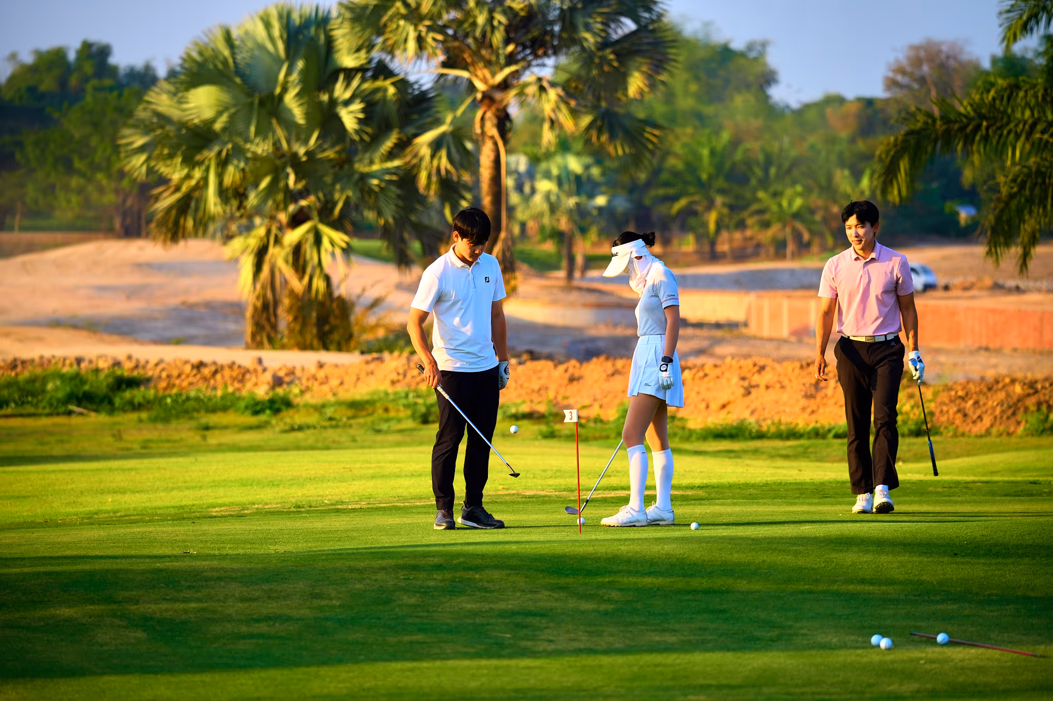 A coach guiding a student's swing at a CRIS golf class